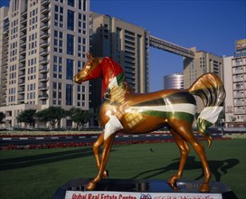 UAE, Dubai, Brightly painted statue of horse with advertising for Dubai Real Estate Centre set in