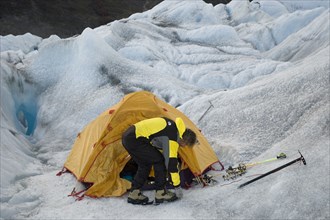 CHILE, "Southern Patagonia,", Glacier Chico, Mountaineer attaching crampons to his boots in front