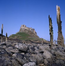ENGLAND, Northumberland, Holy Island, Lindisfarne Castle with barnacle covered rocks and sea-worn