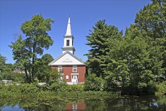 USA, New Hampshire, Harrisville, Community church refelected in pond.