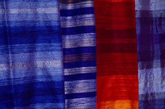 MOROCCO, Essaouira, Detail of red and blue woven textiles.