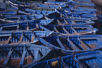 MOROCCO, Essaouira, Blue and green fishing boats moored closely together.
