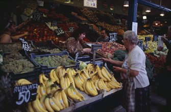 HUNGARY, Budapest, Fruit and vegetable stall in Central Market with woman customer and vendor