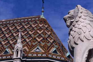 HUNGARY, Budapest, Castle Hill.  Matyas Church  part view of exterior roof and lion statue. Eastern