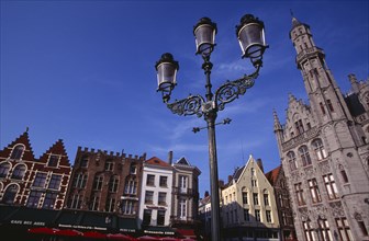BELGIUM, West Flanders, Bruges, The Markt (Market Place).  Line of cafe awnings and red umbrellas