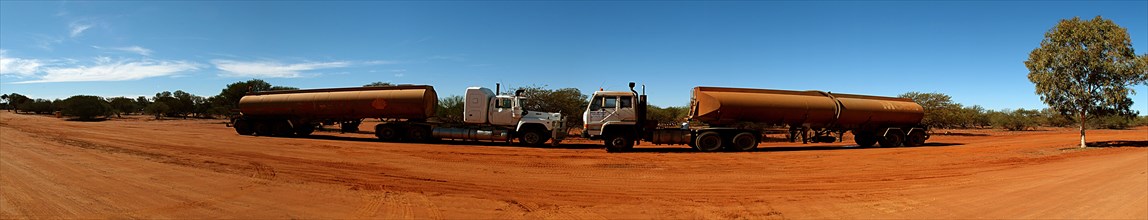Australia, Western Australia, Outback, Panorama of rusting tankers on redut dust dirt road.