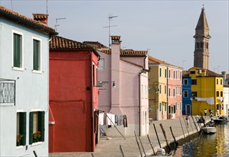 ITALY, Veneto, Venice, Colourful houses beside a canal on Burano. One of the few inhabited islands