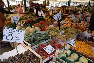 ITALY, Veneto, Venice, The vegetable market with vendor and shoppers beside the produce in the San