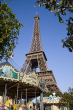 FRANCE, Ile de France, Paris, Funfair carrousel at the base of the Eiffel Tower