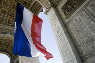 FRANCE, Ile de France, Paris, The French Triclour flag flying beneath the central arch of the Arc