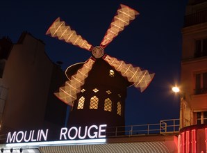 FRANCE, Ile de France, Paris, Montmartre The Moulin Rouge nightclub illuminated at night with the