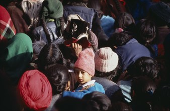 INDIA, Ladakh, Hemis Gompa, "Child in crowd of pilgrims reaching for Holy Thangka of Padmasambhava