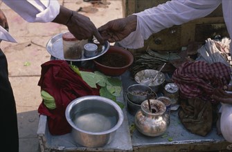 INDIA, North, Markets, Cropped shot of paan seller making transaction with customer across stall