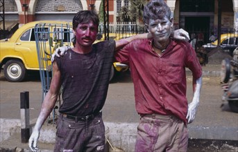 INDIA, West Bengal, Calcutta, Two young men covered in coloured paint during Holi celebrations.