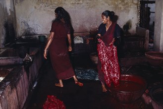 INDIA, West Bengal, Sunderbans, Women dyeing batik fabric in co-operative.