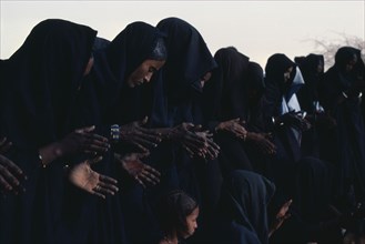 MALI, People, Line of Tuareg women and children wearing typical robes dyed dark indigo.