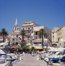FRANCE, Corsica, Calvi, View along marina jetty toward the waterfront cafes and bars.
