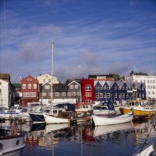 DENMARK, Faroe Islands, Torshavn, Boats moored in harbour with colourful waterfront buildings