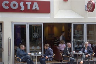 ENGLAND, East Sussex, Brighton, People sat outside the Costa coffee shop in Bond street in the