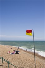 ENGLAND, East Sussex, Brighton, Life guard flag on the beach at Hove.