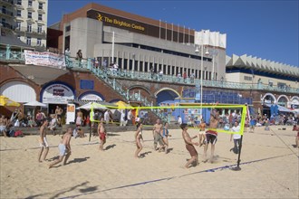 ENGLAND, East Sussex, Brighton, People playing beach volleybal on the sands in front of the