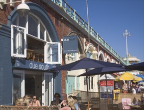 ENGLAND, East Sussex, Brighton, People sat outside the Due South  Restaurant in the arches under
