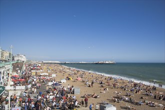 ENGLAND, East Sussex, Brighton, Crowded beach with the Pier on the horizon.