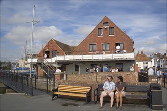 ENGLAND, Hampshire, Emsworth, People sat outside the yacht club.