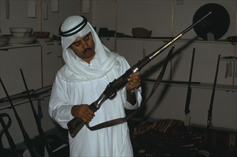 QATAR, Doha, Man holding an old rifle in Doha Museum