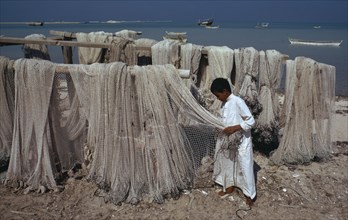 QATAR, Ruwais, Fisherman with nets drying beside the sea