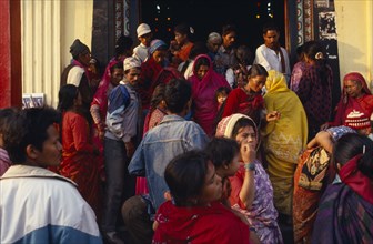 NEPAL, Kathmandu, Colourful crowd scene at temple entrance.