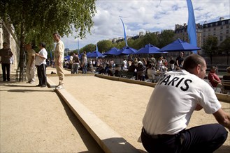 FRANCE, Ile de France, Paris, The Paris Plage urban beach. A man wearing a Paris t-shirt beside