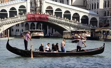 ITALY, Veneto, Venice, A Traghetto carrying local people on board crosses the Grand Canal. Tourists