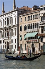 ITALY, Veneto, Venice, A gondola carrying tourists passes the Palazzo Papadopoli (on the left) on