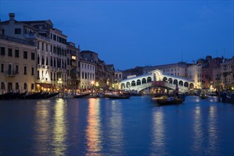 ITALY, Veneto, Venice, The Rialto Bridge spanning the Grand Canal illuminated at night with the