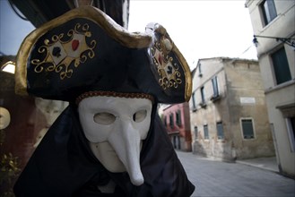 ITALY, Veneto, Venice, Masked Carnival figure outside a shop in the San Polo district