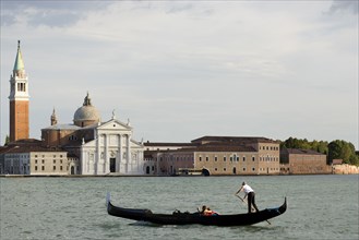 ITALY, Veneto, Venice, A gondola with tourists crosses the Basin of San Marco in front of