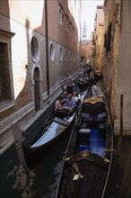 ITALY, Veneto, Venice, Gondolas carrying tourists along the narrow Rio di San Salvadore in the San
