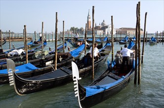 ITALY, Veneto, Venice, Gondoliers prepare gondolas in the Molo San Marco basin in front of