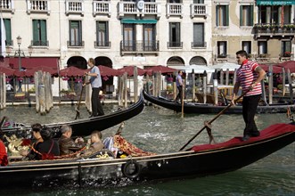 ITALY, Veneto, Venice, Gondoliers taking tourists on gondola rides on the Grand Canal
