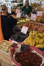 ITALY, Veneto, Venice, Fruit and vegetable stall in the Rialto market with shopper and vendor