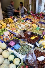 ITALY, Veneto, Venice, Fruit and vegetable stall in the Rialto market with vendors behind the