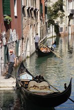 ITALY, Veneto, Venice, A Gondola with tourists passing along a canal in the San Marco district.
