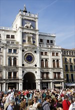 ITALY, Veneto, Venice, Tourists in Piazza San Marco beneath the Torre dell'Orologio clock tower