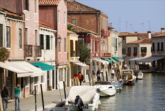 ITALY, Veneto, Venice, Tourists walking past shops along the Fondamenta dei Vetrai with boats