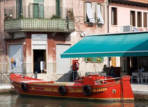 ITALY, Veneto, Venice, A traditional red lagoon barge moored alongside the Fondamenta Sebastiano