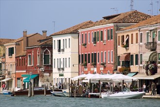 ITALY, Veneto, Venice, Boats on the Canale Grande di Murano moored beside restuarants on the