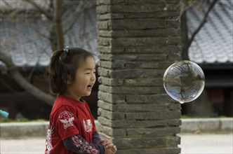 JAPAN, Honshu, Kyoto, Child playing with bubbles near Maruyama-koen Park