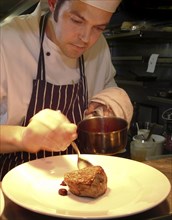 ENGLAND, Bristol, Bristol, Chef Plating Up Fillet Steak and Raspberry Coulis