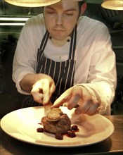 ENGLAND, Bristol, Bristol, Chef Plating Up Fillet Steak and Raspberry Coulis